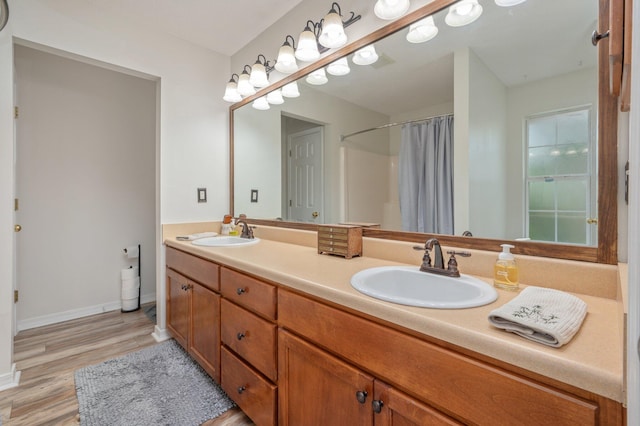5420 Flag Tail Ln, Crestview, FL 32539 - bathroom with double vanity, wood finished floors, baseboards, and a shower with shower curtain