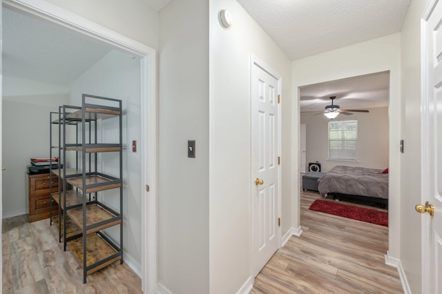 5420 Flag Tail Ln, Crestview, FL 32539 - hallway with light wood-style floors, a textured ceiling, and baseboards