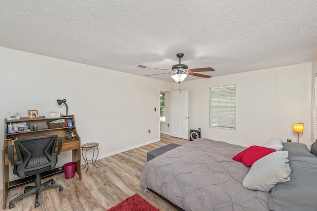 5420 Flag Tail Ln, Crestview, FL 32539 - bedroom with wood finished floors, a textured ceiling, baseboards, a ceiling fan, and an office area