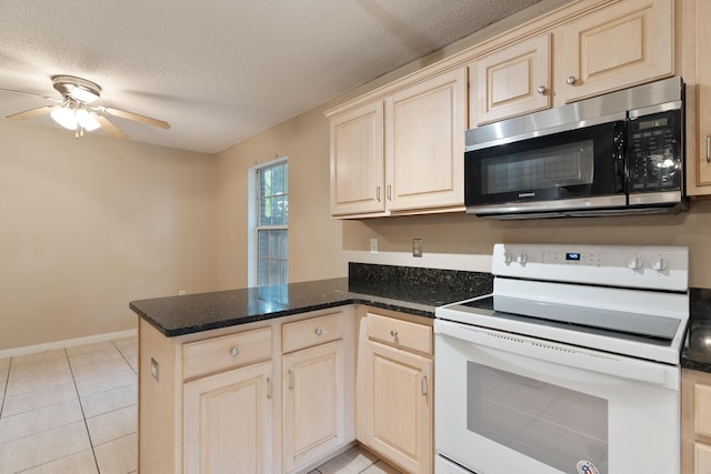 209 Warrior St, Crestview, FL 32536 - kitchen featuring stainless steel microwave, white range with electric cooktop, a peninsula, light brown cabinetry, and a textured ceiling