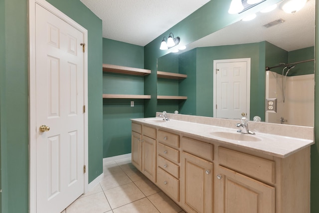 209 Warrior St, Crestview, FL 32536 - full bath featuring tile patterned floors, double vanity, a textured ceiling, and baseboards