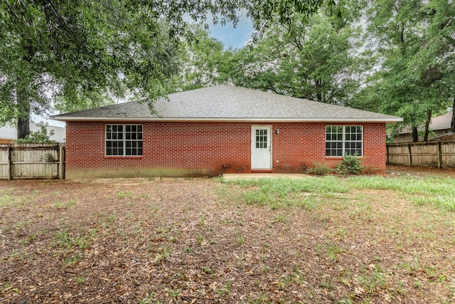 209 Warrior St, Crestview, FL 32536 - rear view of property with a fenced backyard, brick siding, and a shingled roof
