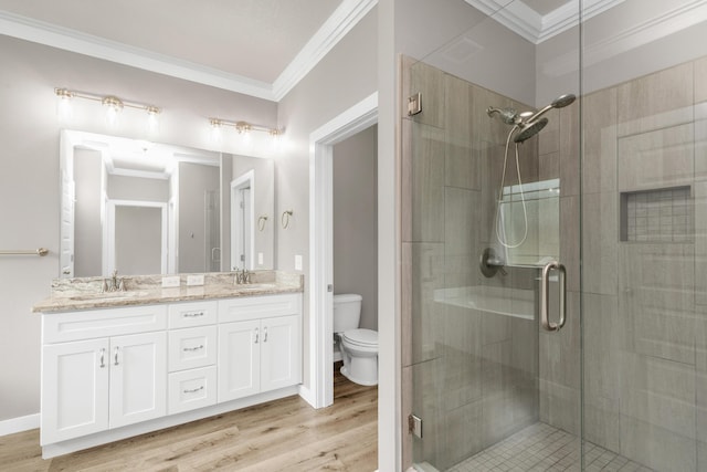 6437 Amanda Ct, Crestview, FL 32536 - bathroom featuring double vanity, a shower stall, toilet, wood finished floors, and crown molding