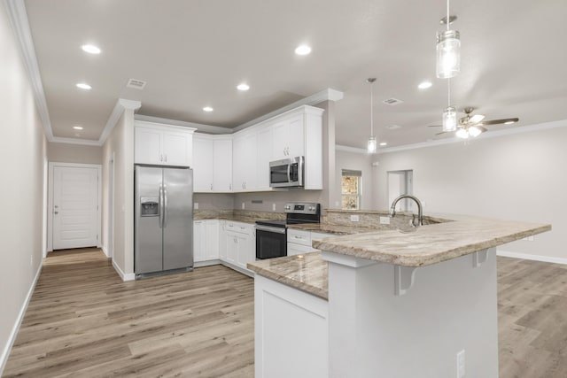6437 Amanda Ct, Crestview, FL 32536 - kitchen with stainless steel appliances, ornamental molding, a peninsula, light wood-style flooring, and baseboards