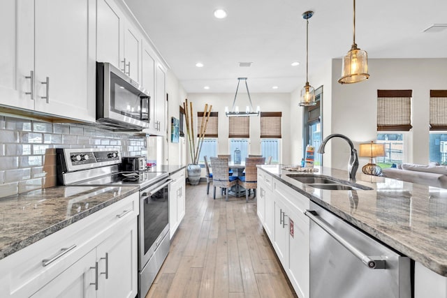 151 Penelope St, Miramar Beach, FL 32550 - kitchen with stainless steel appliances, a sink, backsplash, white cabinetry, and recessed lighting