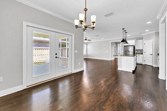50 Oyster Blvd, Freeport, FL 32439 - unfurnished living room featuring french doors, crown molding, a chandelier, baseboards, and dark wood-style floors