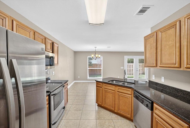 2909 Five Oaks Ln, Shalimar, FL 32579 - kitchen featuring appliances with stainless steel finishes, light tile patterned floors, dark stone countertops, a chandelier, and a peninsula