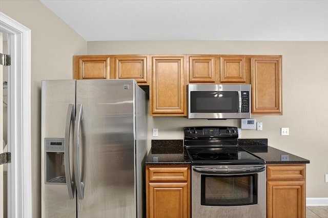 2909 Five Oaks Ln, Shalimar, FL 32579 - kitchen with stainless steel appliances, dark stone countertops, and brown cabinets
