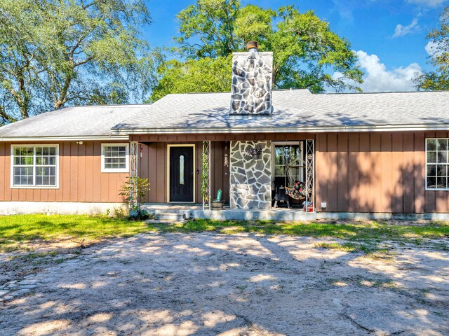 3241 Auburn Rd, Crestview, FL 32539 - view of front facade featuring a chimney, a shingled roof, and board and batten siding