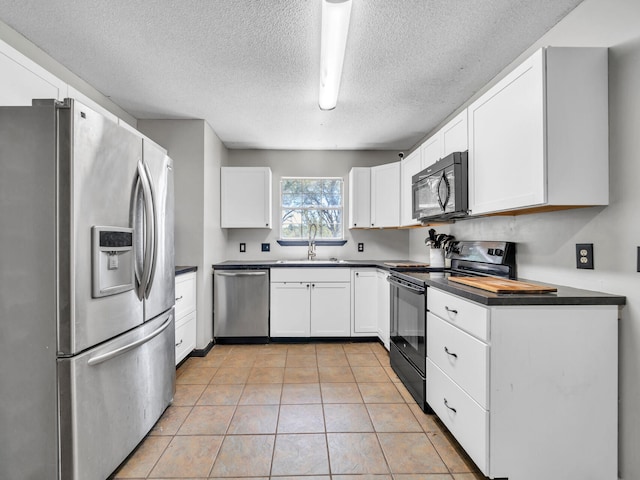 3241 Auburn Rd, Crestview, FL 32539 - kitchen featuring black appliances, dark countertops, a textured ceiling, white cabinets, and light tile patterned flooring