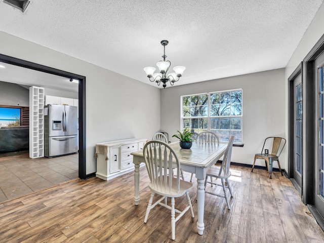 3241 Auburn Rd, Crestview, FL 32539 - dining area featuring a textured ceiling, a chandelier, and wood finished floors