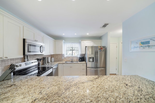 25 Misty Cv Unit 115, Miramar Beach, FL 32550 - kitchen featuring appliances with stainless steel finishes, a sink, light stone counters, backsplash, and recessed lighting