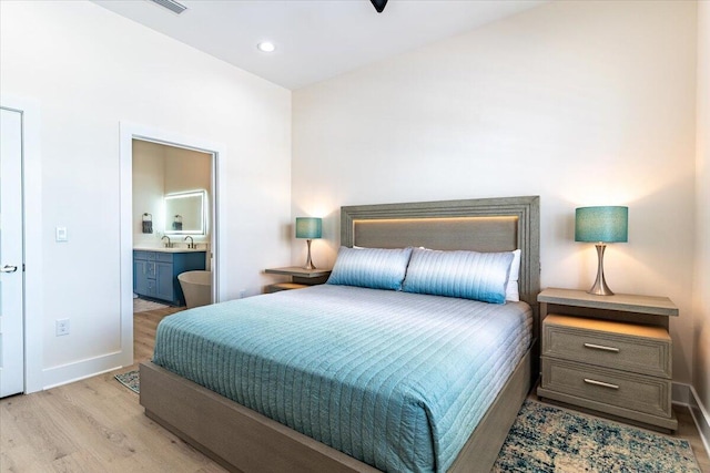 8169 White Sands Blvd, Navarre, FL 32566 - bedroom featuring wood finished floors, baseboards, connected bathroom, a sink, and recessed lighting