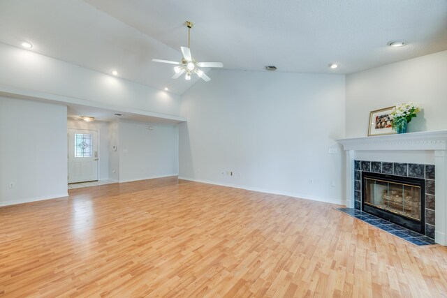 2803 Macgregor Ln, Crestview, FL 32539 - unfurnished living room with a tiled fireplace, wood finished floors, a ceiling fan, vaulted ceiling, and baseboards