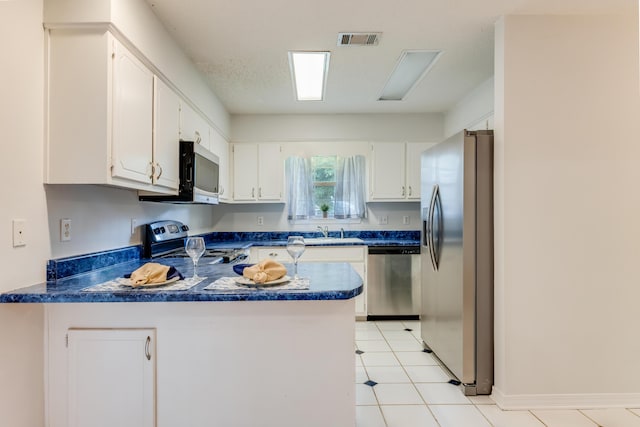 2803 Macgregor Ln, Crestview, FL 32539 - kitchen with appliances with stainless steel finishes, a peninsula, dark countertops, a sink, and white cabinets