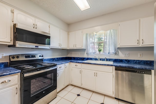 2803 Macgregor Ln, Crestview, FL 32539 - kitchen with appliances with stainless steel finishes, dark countertops, white cabinets, a sink, and light tile patterned flooring