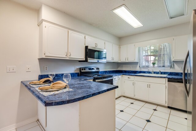 2803 Macgregor Ln, Crestview, FL 32539 - kitchen with appliances with stainless steel finishes, a sink, a peninsula, dark countertops, and white cabinets
