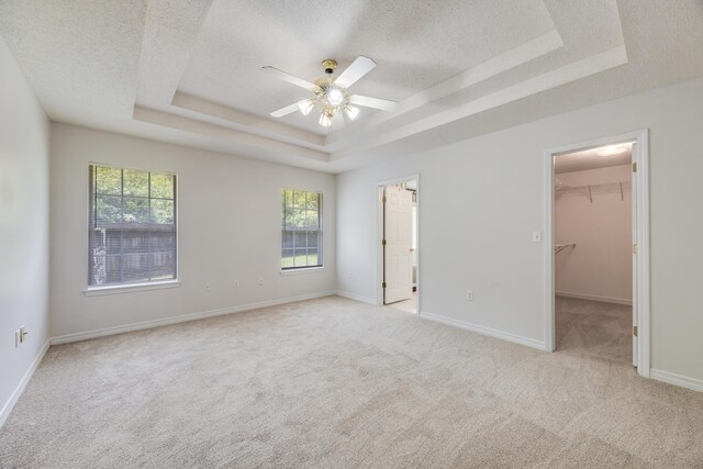 2803 Macgregor Ln, Crestview, FL 32539 - unfurnished bedroom with a raised ceiling, multiple windows, a textured ceiling, light colored carpet, and a spacious closet