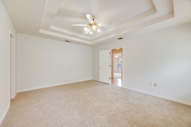 2803 Macgregor Ln, Crestview, FL 32539 - empty room with a tray ceiling, light carpet, ceiling fan, and baseboards