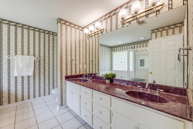 2803 Macgregor Ln, Crestview, FL 32539 - full bathroom featuring toilet, double vanity, tile patterned floors, a stall shower, and wallpapered walls