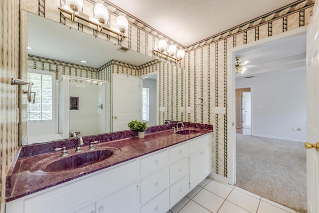 2803 Macgregor Ln, Crestview, FL 32539 - bathroom featuring wallpapered walls, a shower stall, double vanity, a textured ceiling, and a ceiling fan