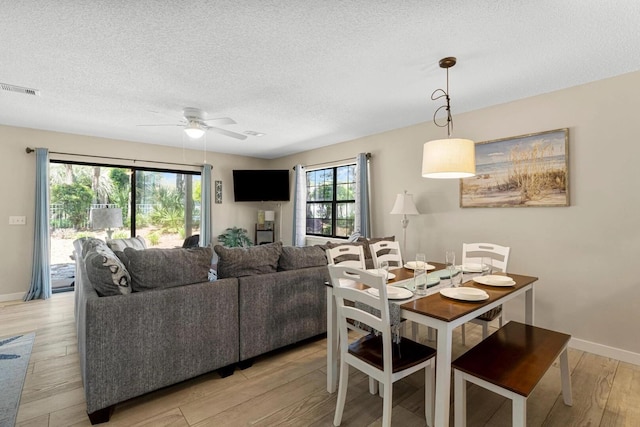 15 Cypress St Unit 268, Santa Rosa Beach, FL 32459 - dining room with light wood-type flooring, a ceiling fan, a textured ceiling, and baseboards
