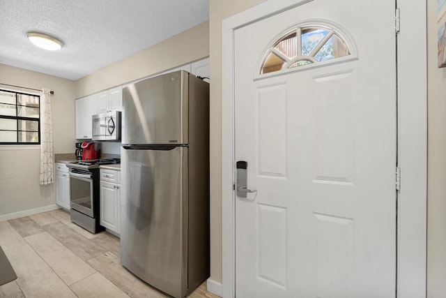 15 Cypress St Unit 268, Santa Rosa Beach, FL 32459 - kitchen featuring appliances with stainless steel finishes, a textured ceiling, white cabinetry, baseboards, and light countertops