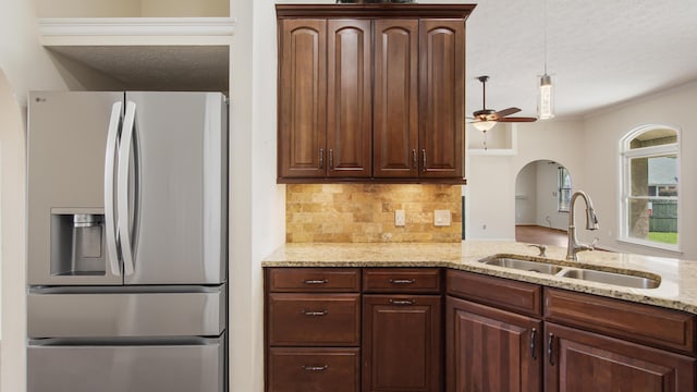 108 Colony Bay Harbour Dr, Panama City Beach, FL 32407 - kitchen with stainless steel fridge with ice dispenser, a sink, decorative backsplash, a textured ceiling, and arched walkways