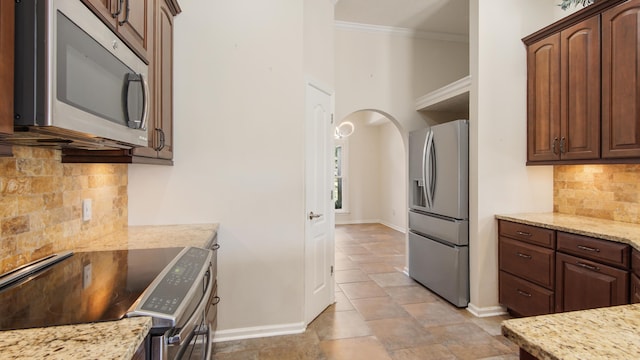 108 Colony Bay Harbour Dr, Panama City Beach, FL 32407 - kitchen featuring appliances with stainless steel finishes, baseboards, tasteful backsplash, crown molding, and light stone countertops