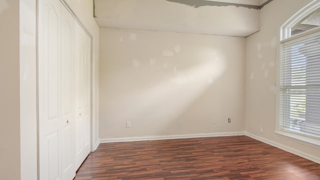108 Colony Bay Harbour Dr, Panama City Beach, FL 32407 - unfurnished bedroom with dark wood finished floors, multiple windows, baseboards, and a closet