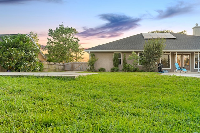 108 Colony Bay Harbour Dr, Panama City Beach, FL 32407 - rear view of property featuring solar panels, a patio, stucco siding, a shingled roof, and a chimney