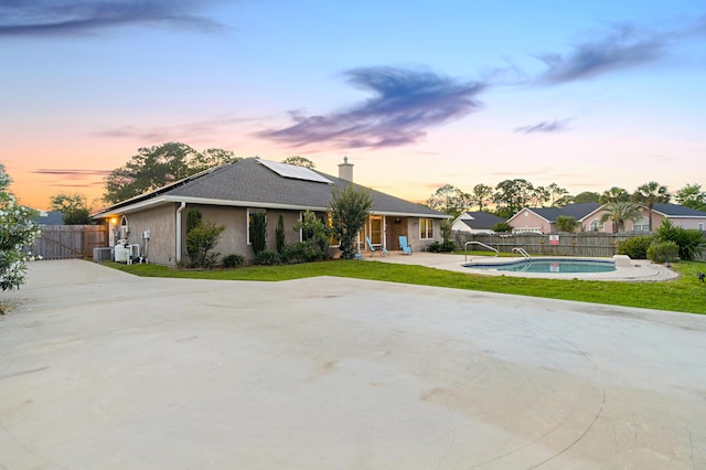 108 Colony Bay Harbour Dr, Panama City Beach, FL 32407 - ranch-style house featuring solar panels, a fenced backyard, a patio area, a chimney, and central AC unit