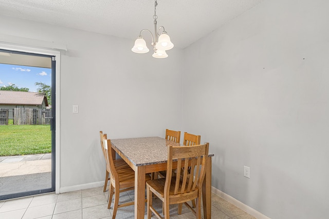 617 Schneider Dr, Fort Walton Beach, FL 32547 - dining room featuring a chandelier, light tile patterned flooring, baseboards, and a textured ceiling