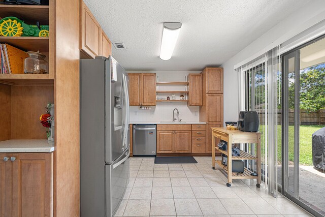 617 Schneider Dr, Fort Walton Beach, FL 32547 - kitchen featuring appliances with stainless steel finishes, open shelves, a sink, light countertops, and light tile patterned floors