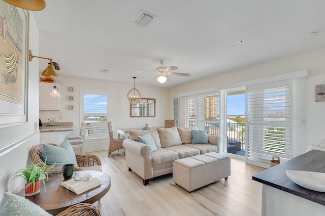 8436 Gulf Blvd Unit 734, Navarre, FL 32566 - living room featuring a ceiling fan, light wood-style floors, and a chandelier