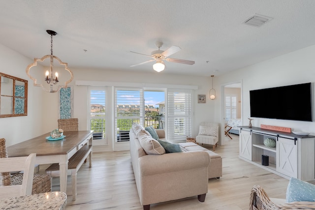 8436 Gulf Blvd Unit 734, Navarre, FL 32566 - living room featuring a chandelier, light wood-type flooring, a textured ceiling, and ceiling fan
