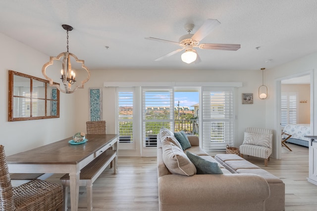 8436 Gulf Blvd Unit 734, Navarre, FL 32566 - living room featuring a chandelier, healthy amount of natural light, light wood-style floors, and a textured ceiling