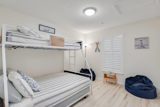 8436 Gulf Blvd Unit 734, Navarre, FL 32566 - bedroom with attic access, wood finished floors, baseboards, and a textured ceiling