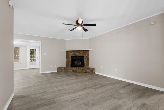 3437 Auburn Rd, Crestview, FL 32539 - unfurnished living room featuring a ceiling fan, baseboards, wood finished floors, crown molding, and a stone fireplace