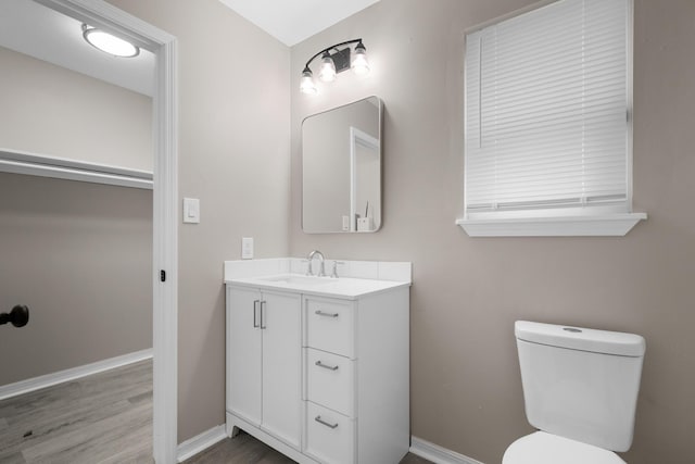 3437 Auburn Rd, Crestview, FL 32539 - half bathroom with vanity, baseboards, wood finished floors, and toilet