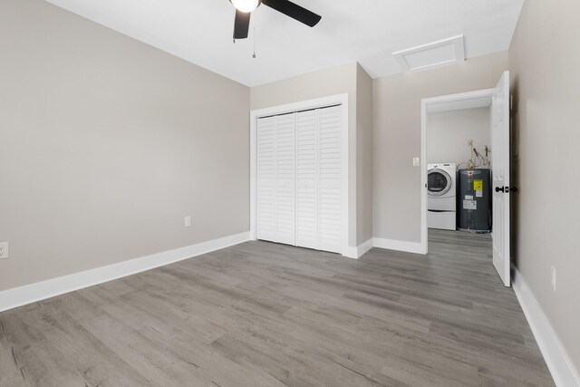 3437 Auburn Rd, Crestview, FL 32539 - unfurnished bedroom with water heater, washer / dryer, attic access, a closet, and wood finished floors