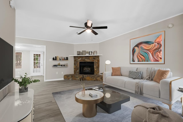 3437 Auburn Rd, Crestview, FL 32539 - living room featuring wood finished floors, a ceiling fan, baseboards, crown molding, and a stone fireplace