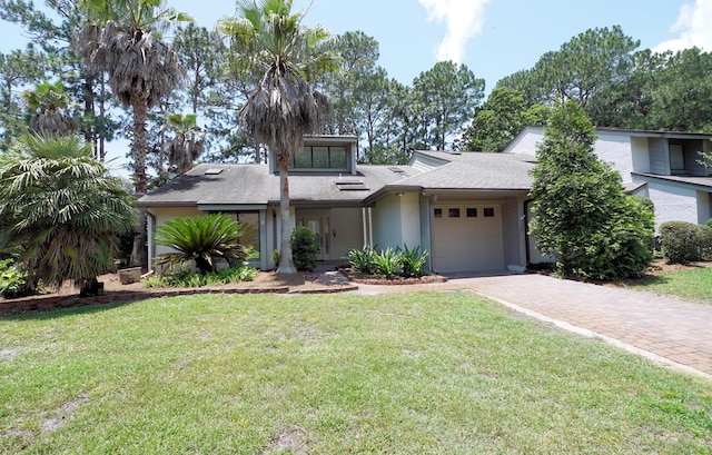 115 Gleneagles Dr, Niceville, FL 32578 - mid-century modern home with a garage, decorative driveway, a front lawn, and stucco siding