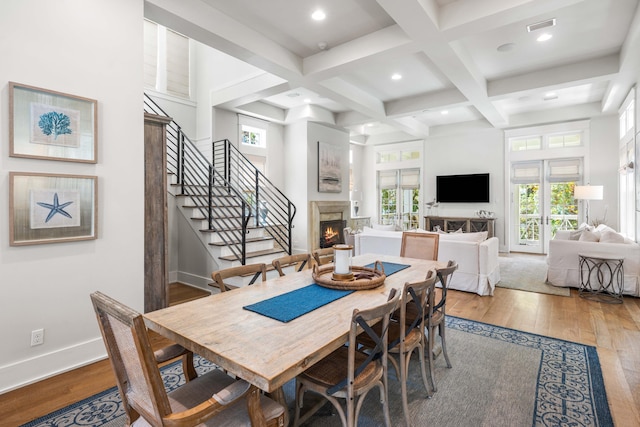 21 Founders Ct, Watersound, FL 32461 - dining area with a lit fireplace, hardwood / wood-style flooring, beamed ceiling, coffered ceiling, and stairway