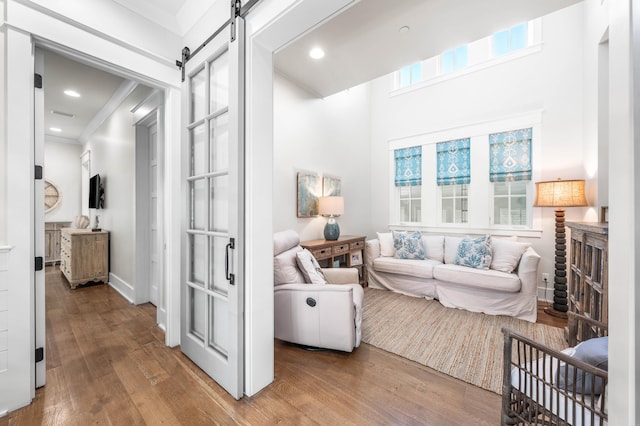 21 Founders Ct, Watersound, FL 32461 - living area featuring hardwood / wood-style floors, a barn door, ornamental molding, and recessed lighting