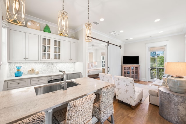 21 Founders Ct, Watersound, FL 32461 - kitchen with open floor plan, wood finished floors, light stone countertops, recessed lighting, and glass insert cabinets