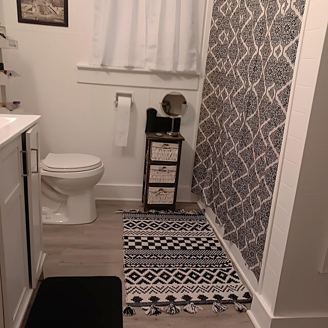 72 Park Ave, Defuniak Springs, FL 32435 - full bath featuring toilet, vanity, baseboards, and curtained shower