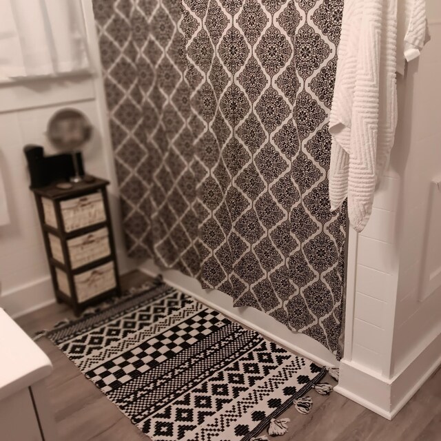 72 Park Ave, Defuniak Springs, FL 32435 - bathroom featuring a shower with shower curtain and wood finished floors