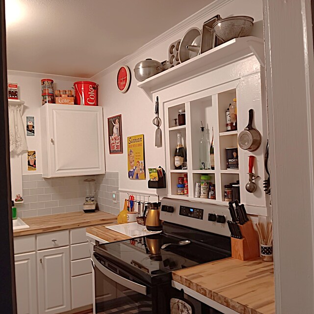 72 Park Ave, Defuniak Springs, FL 32435 - kitchen with stainless steel electric range, butcher block counters, white cabinets, tasteful backsplash, and crown molding