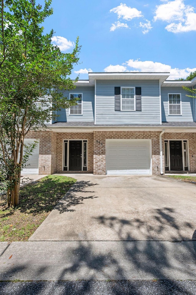996 Leigh Ann Ln, Fort Walton Beach, FL 32547 - view of property featuring a garage, brick siding, and concrete driveway